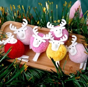 Close-up of reindeer photo clips with colorful plush pom poms for Christmas decor
