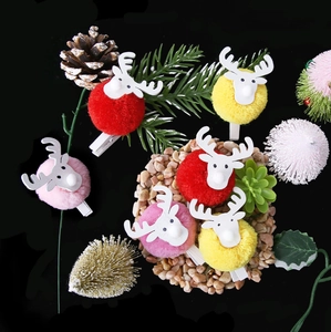 Detailed view of plush reindeer clips with pine cones and festive Christmas decorations