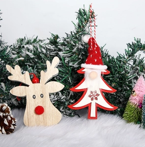 Detail view of wooden reindeer and Santa Claus ornaments with knitted hats on pine branches