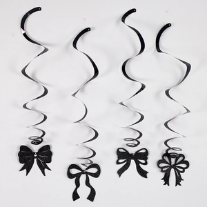 Detail of four black spiral hanging decorations with glittery bow charms on white background