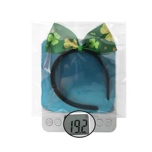 Close-up of St. Patrick's Day green clover bow headband being weighed on a scale