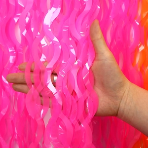 Dettaglio della gonna da tavolo ondulata rosa neon in plastica per decorazioni di feste