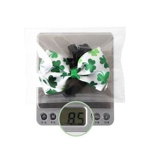 Macro detail of St. Patrick's Day clover bow tie weighing 8.5g on a digital scale