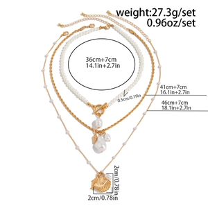 Détails d'un ensemble de colliers de perles baroques superposés avec pendentifs coquillages