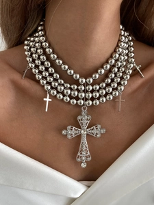 Gros plan sur un collier de perles multicouches de luxe avec pendentifs croix en strass