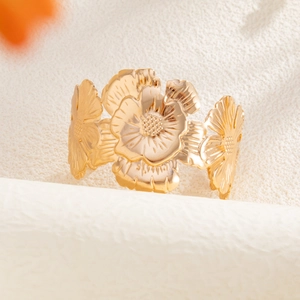 Elegant wide open bangle featuring layered golden metallic flowers with detailed petals