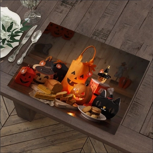 Detail of Halloween linen placemat featuring pumpkins and black cats on wood background