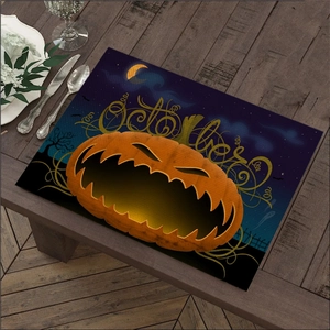 Detail of Halloween linen placemat featuring a pumpkin and October text on wood