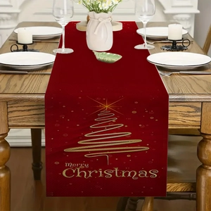 Detail of red linen Christmas table runner with gold tree and Merry Christmas lettering