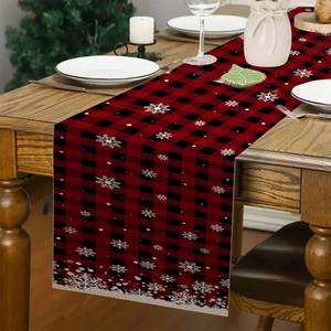 Close-up of red and black buffalo plaid Christmas table runner with white snowflakes