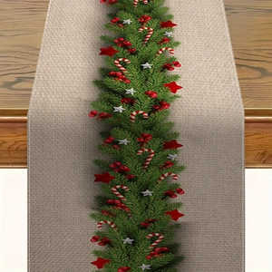 Close-up of linen Christmas table runner featuring pine wreaths, berries and candy canes