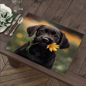 Close-up of linen place mat with black puppy print and yellow flower on a wooden table