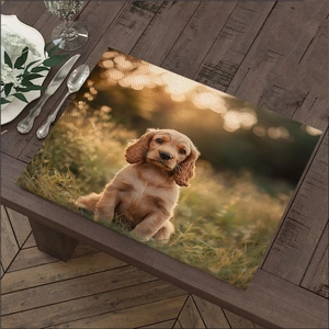 Detail of cotton linen placemat featuring a golden puppy print on wooden table