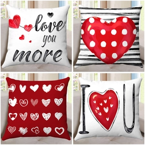 Set of 4 Valentine's Day heart throw pillow covers with love letters on a beige sofa