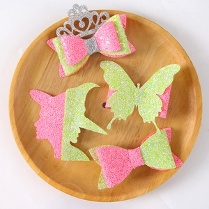 Close-up of pink and green glitter hair clips set with crown and butterfly details