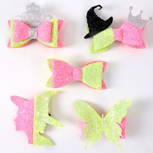 Detailed set of pink and green glitter hair clips with crown and witch hat designs