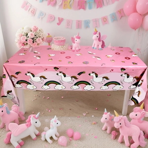 Detailed view of pink unicorn tablecloth with rainbow and dessert prints for party