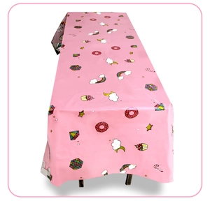 Detailed pattern of unicorn party tablecloth with rainbow, donut, and cupcake prints