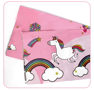 Detail of pink unicorn party tablecloth with rainbow prints and waterproof PE material