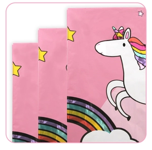 Close-up of pink unicorn and rainbow party favor bags with white star and cloud patterns