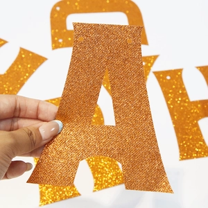 Detail van de oranje glitter letterslinger voor verjaardagsfeestjes met dinothema