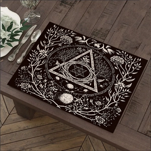 Detail van donkere boho linnen placemat met witte occulte symbolen op houten tafel