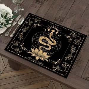 Detail van bohemien linnen placemat in zwart en goud met slang en lotusbloem motieven
