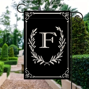Dettaglio bandiera da giardino con lettera F e ghirlanda di alloro su tela nera