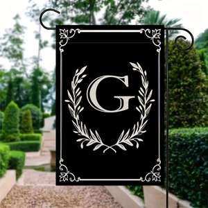 Dettaglio della bandiera da giardino con monogramma G e corona di alloro su asta nera