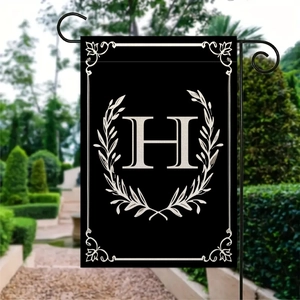 Dettaglio bandiera da giardino con lettera H bianca e corona di alloro su tessuto nero