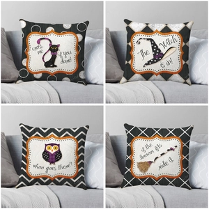 Set of four Halloween throw pillow covers with spooky motifs on a modern grey sofa