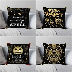 Set of four Halloween pillow covers with gold bat and skull prints on black fabric