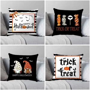 Set of four Halloween pillow covers with witch, ghost, and bat prints on a sofa