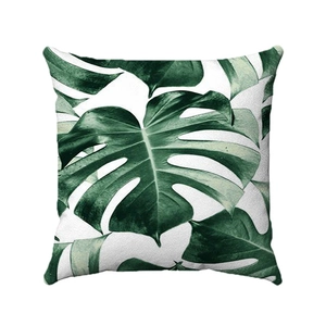 Detail of square cushion cover featuring realistic green monstera leaf print