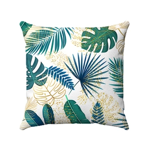 Close-up of square pillowcase with green tropical leaves and gold glitter vein details