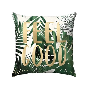 Detail of tropical monstera leaf print on soft cushion cover with Feel Good gold text