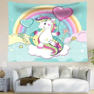 Detail of cartoon unicorn tapestry with rainbow and clouds hung over a sofa in a bedroom