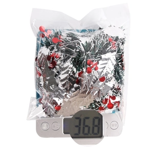 Macro detail of 2m Christmas garland with white trim and red berries showing 36.8g weight