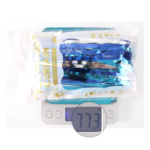Blue and silver fringe curtain in packaging on an electronic scale weighing 77.3g