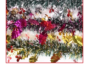 Close-up of green and white Christmas tinsel garland with red berry and gold leaf accents