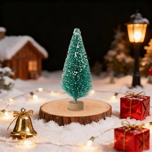 Miniature green Christmas tree with fake snow detail on a rustic wooden base for tabletop