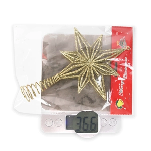 Detailed view of a gold glitter Christmas tree star topper in packaging weighing 36.6g