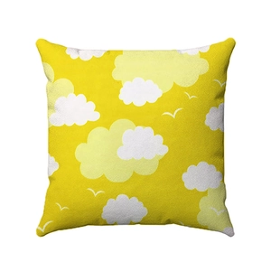 Close-up of yellow geometric pillow case with white cloud patterns and bird silhouettes