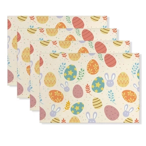 Nahaufnahme von vier Oster-Tischsets aus Leinen mit bunten Eiern und Hasenmotiven
