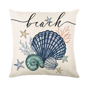 Linen beach cushion cover with printed sea shells, starfish, and coral on white background
