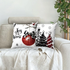 Lot de deux housses de coussin de Noël avec imprimé Joy to the World sur canapé gris