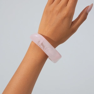 Macro shot of a chunky pink marble resin bangle with translucent white textures on wrist