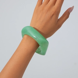 Close-up of translucent light green acrylic bangle with marbled cloud texture on wrist