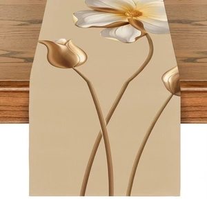 Linen table runner featuring elegant white and gold floral patterns on a wooden table