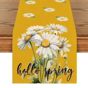 Close-up of linen table runner with white daisies and Hello Spring text on yellow fabric